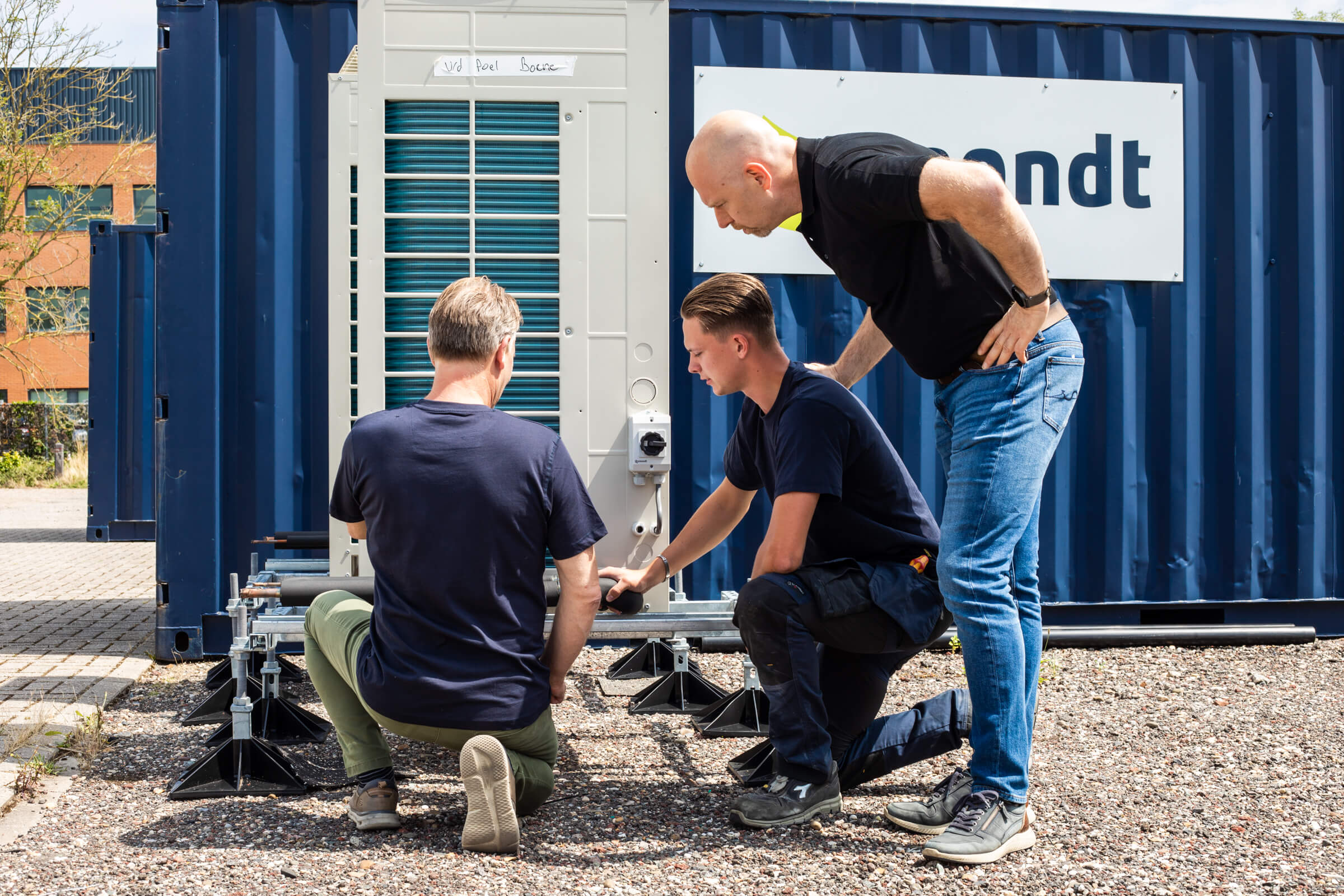 Monteur in opleiding krijgt uitleg bij een koelinstallatie